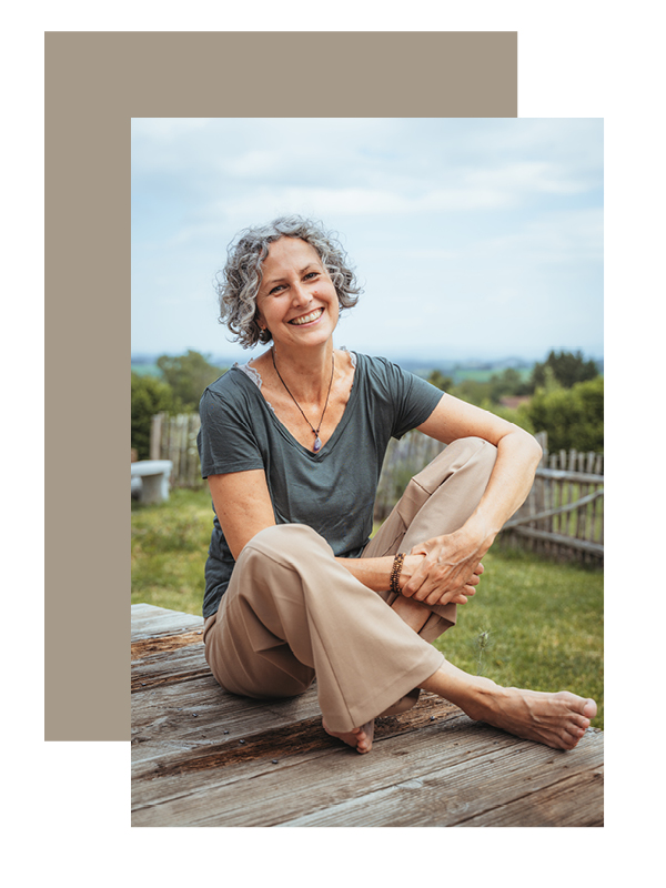 Potrait von Dagmar Mösle in Vogt. Sie sitzt draußen mit Weitblick im Hintergrund und lacht in die Kamera.